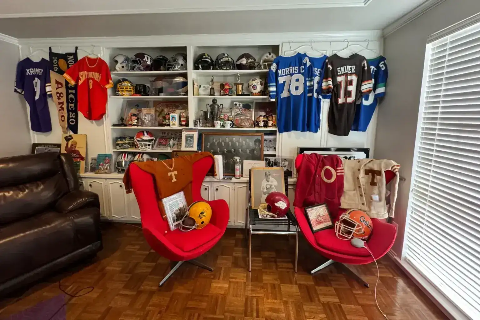 Estate sale sports memorabilia — Collection room with vintage jerseys, football helmets and Texas Longhorns memorabilia filling the walls and shelves
