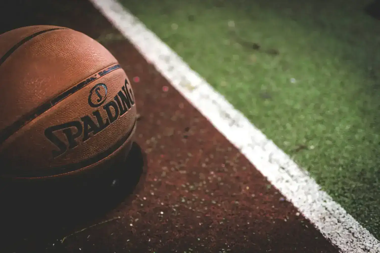 Sell autographed jerseys — Spalding basketball resting on an outdoor court line