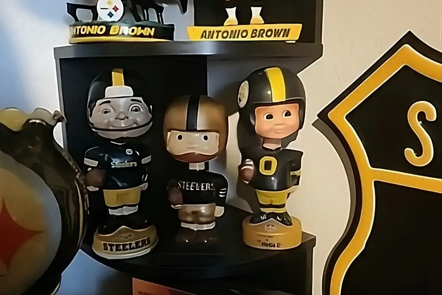 Sell sports bobbleheads — Pittsburgh Steelers bobblehead collection including Antonio Brown figures on a display shelf
