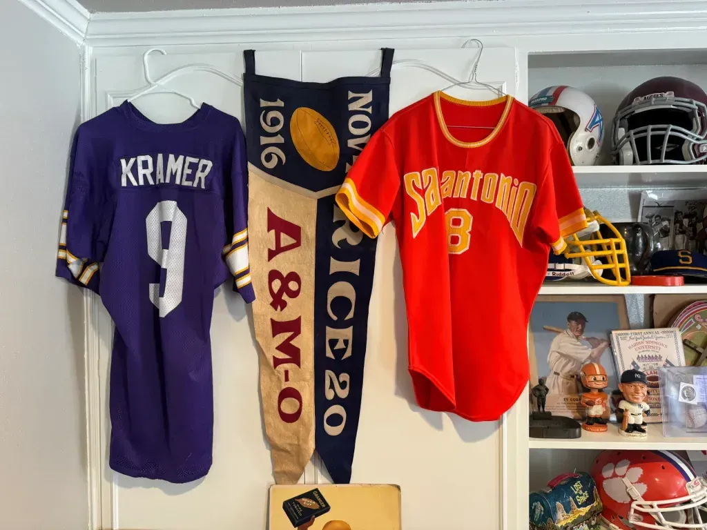 Sell vintage sports memorabilia in San Antonio Tx — Jerry Kramer jersey, a 1916 Rice versus Texas A&M football pennant and a San Antonio jersey on hangers