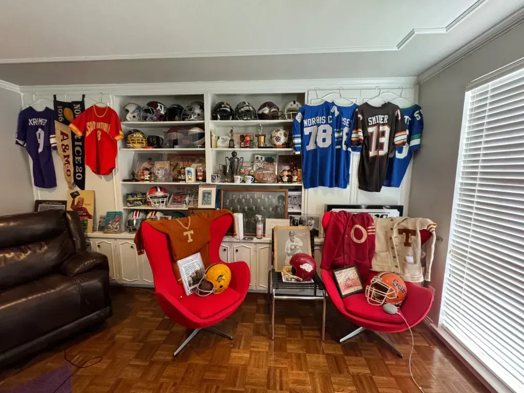 Sell vintage sports memorabilia in San Antonio Tx — Collection room with vintage jerseys, football helmets and Texas Longhorns memorabilia filling the walls and shelves
