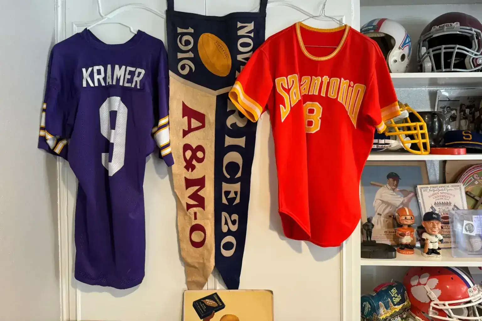 Sell vintage sports memorabilia in Schertz Tx — Jerry Kramer jersey, a 1916 Rice versus Texas A&M football pennant and a San Antonio jersey on hangers
