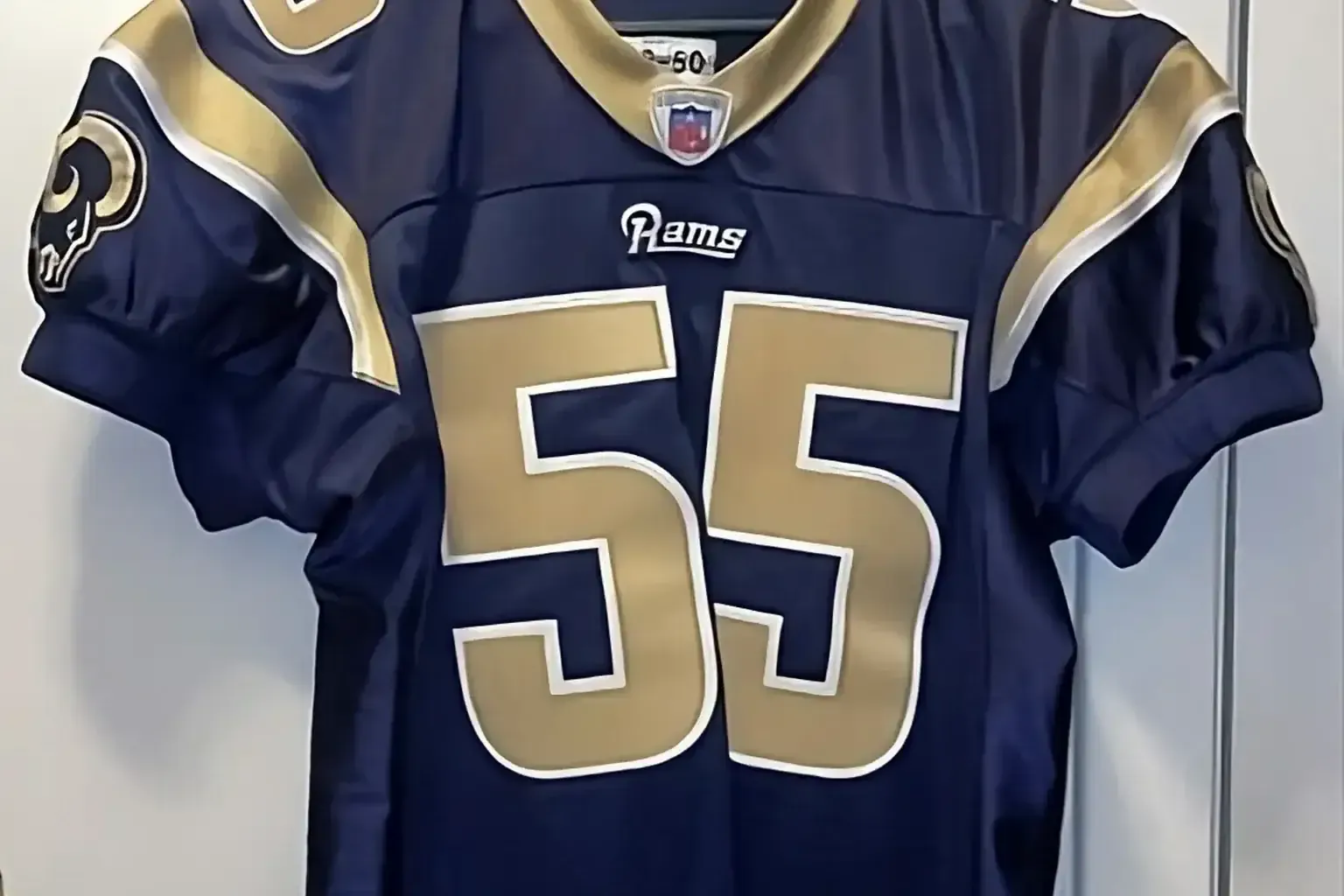 Vintage sports pennants — Authentic Los Angeles Rams number 55 NFL game jersey on a hanger
